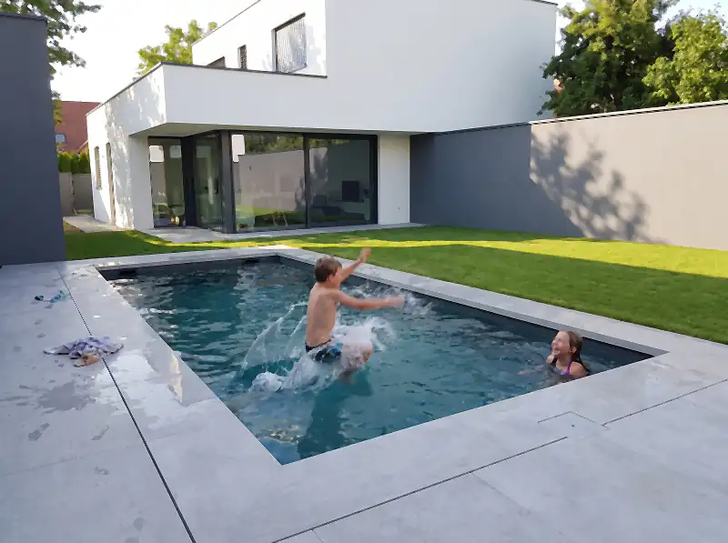 Copil sărind în piscina unei curți moderne